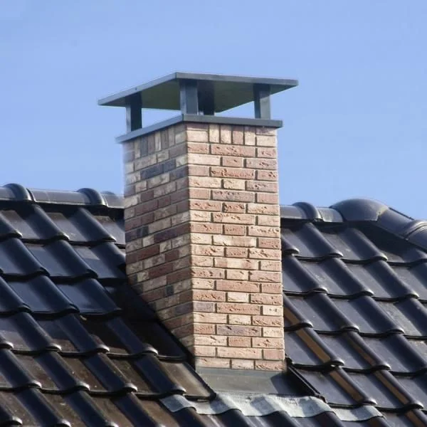 Brick chimney with cap on tile roof