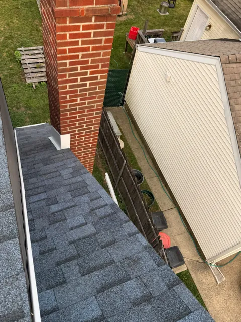 Brick chimney and shingle roof junction