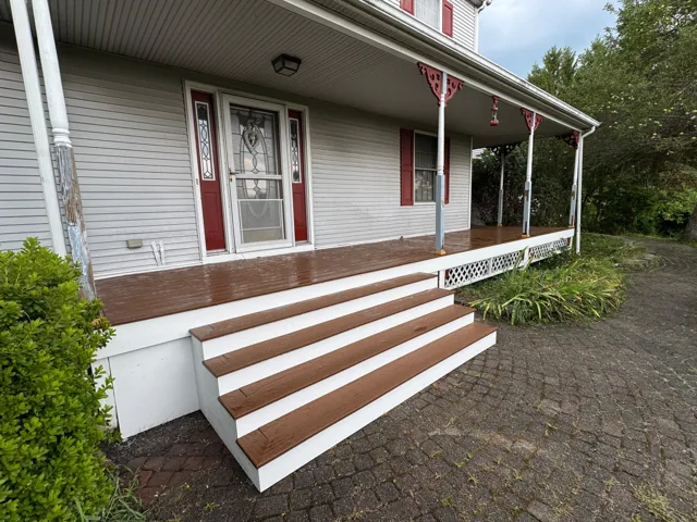 Covered front porch with broad steps and white trim