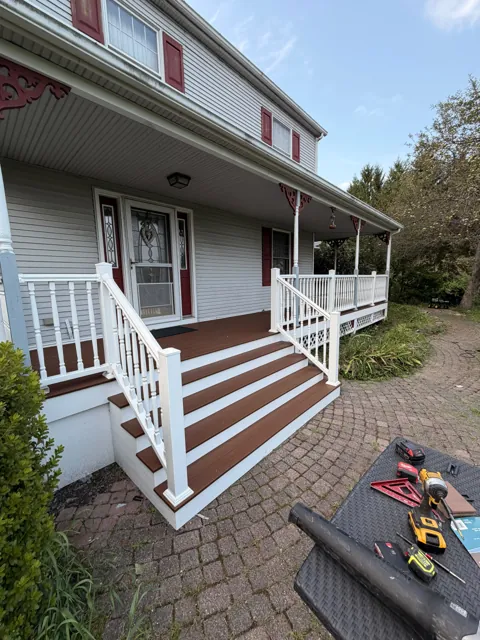 Front porch with white railings and wide steps