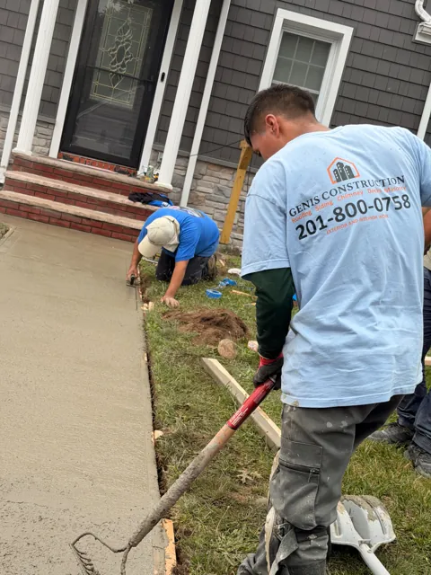 Genis Construction team finishing a concrete walkway