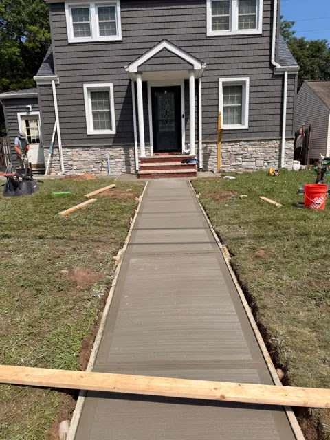 Straight concrete walkway leading to a front entry