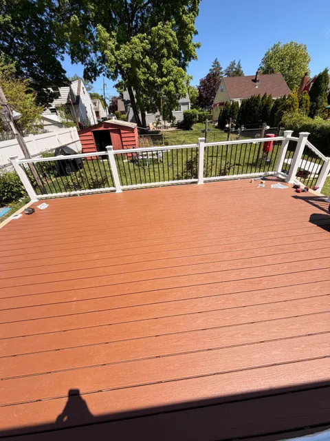 Warm wood deck boards with white perimeter railing